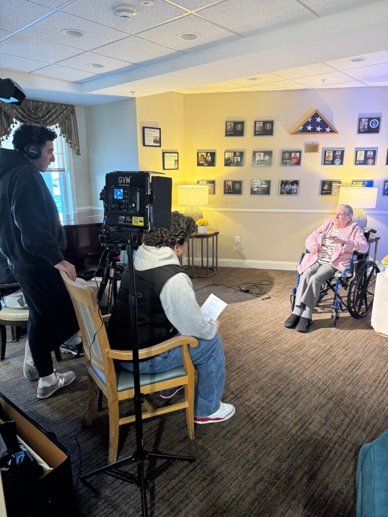 Students interview a woman in front of a camera