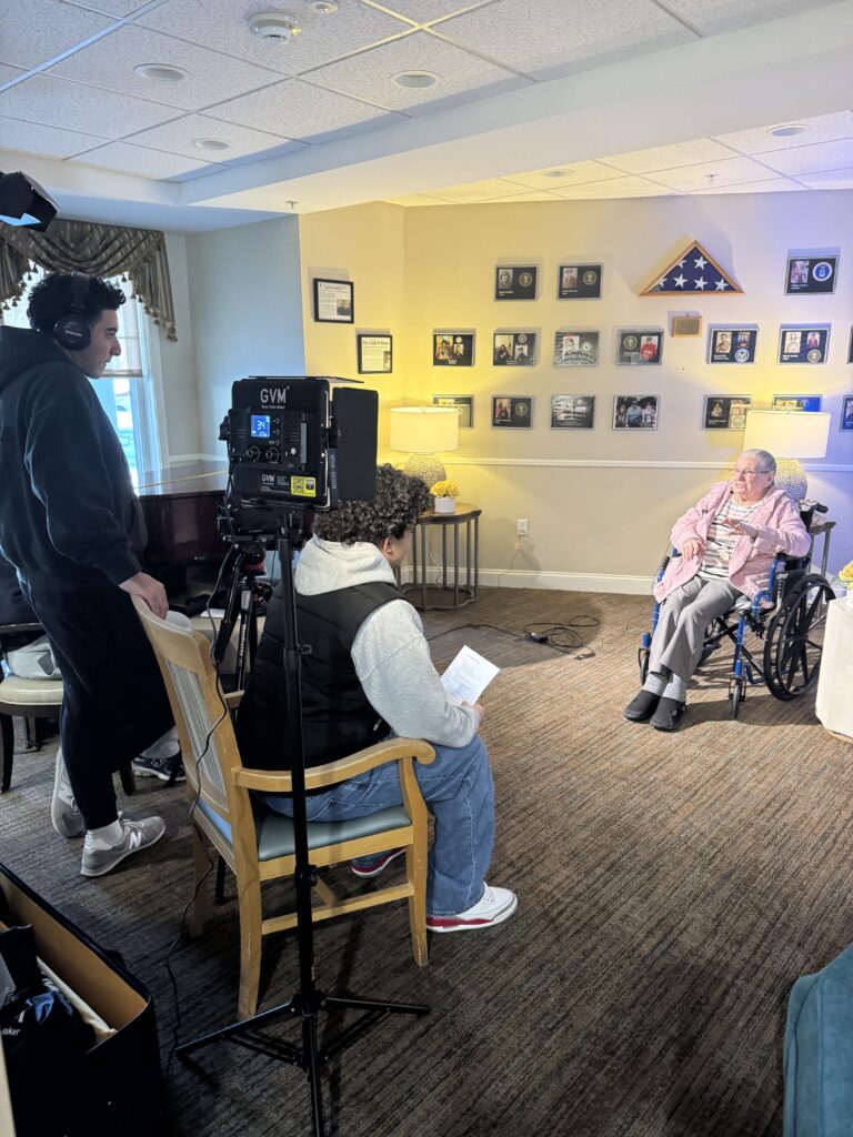 Students interview a woman in front of a camera