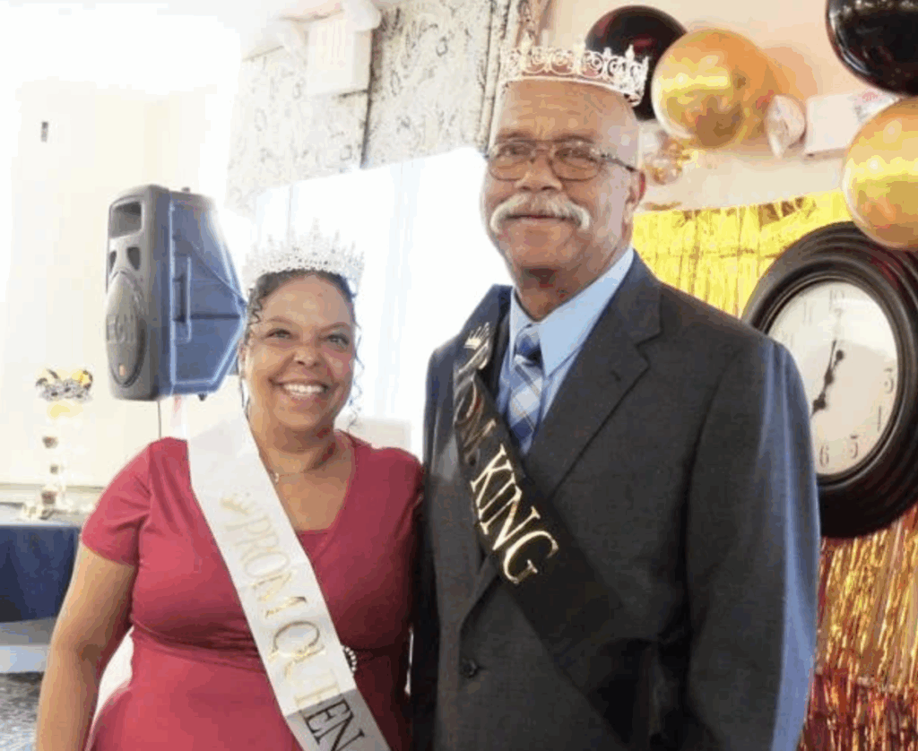 Woman and man in prom crowns and sashes, smiling