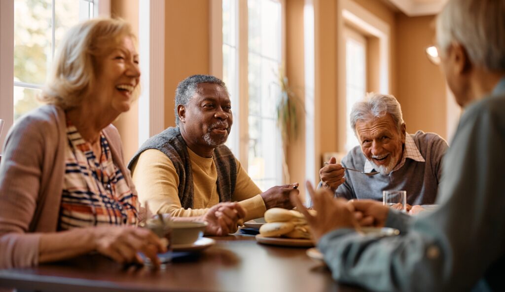 Group of seniors laughing at a dining table