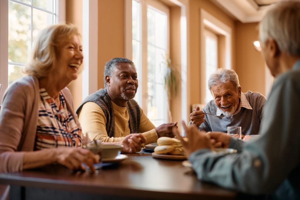 Group of seniors laughing at a dining table