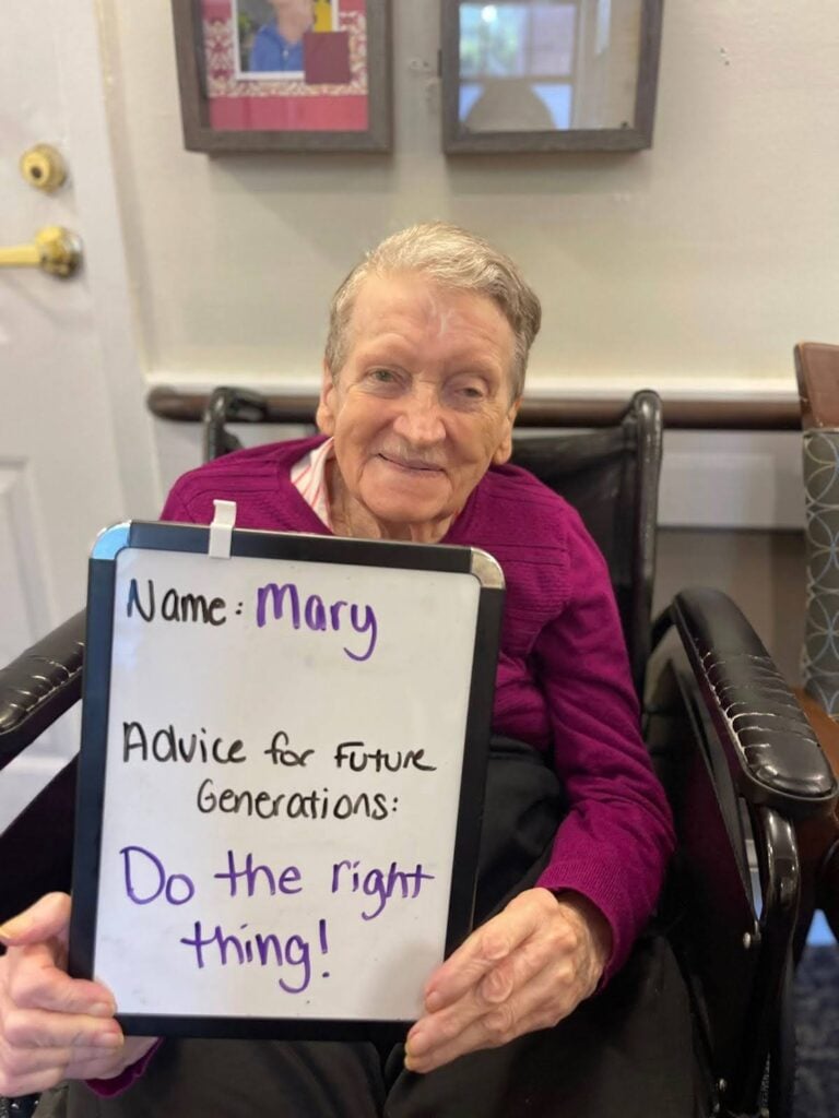 Mary smiles and holds up a whiteboard that reads "do the right thing!"