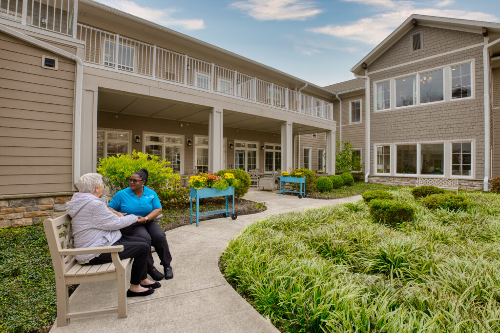 Resident and staff chatting in the Compass Courtyard
