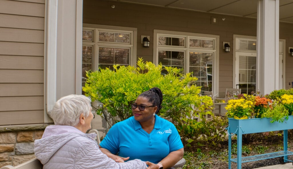 Resident and staff chatting in the Compass Courtyard