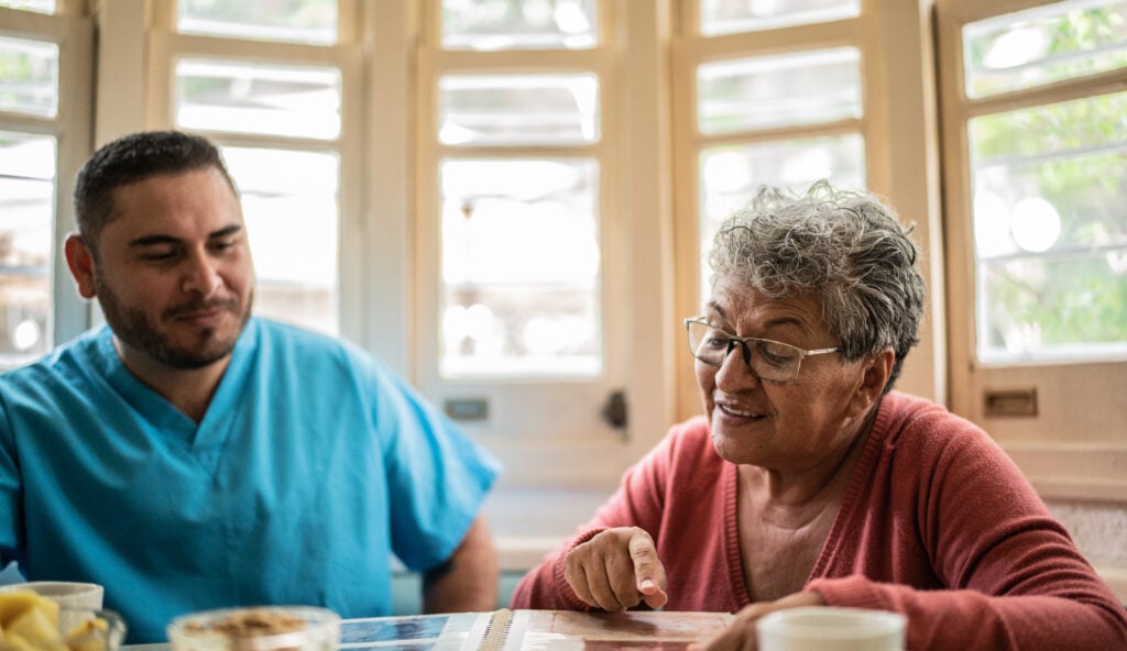 Caregiver and senior reading book