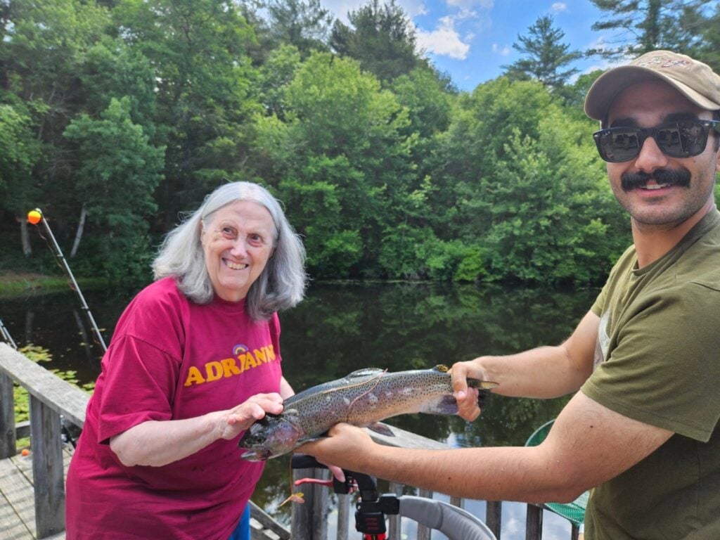 Senior and caregiver fishing