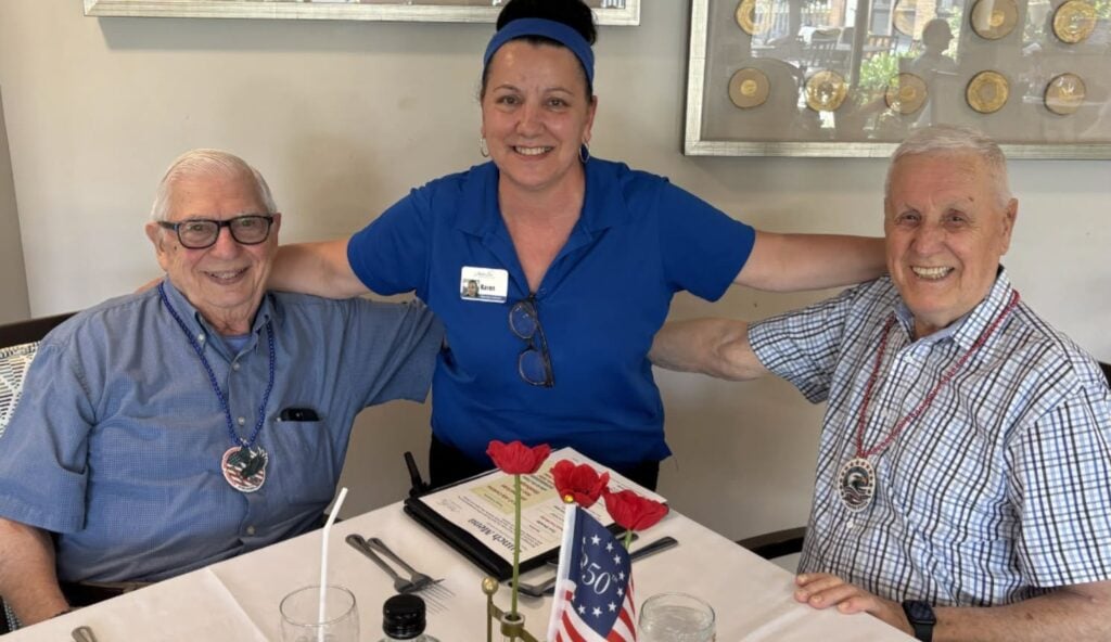 Seniors and caregiver posing at 4th of July celebration