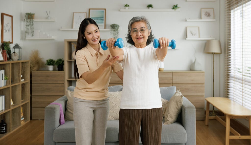Senior and caregiver doing exercises