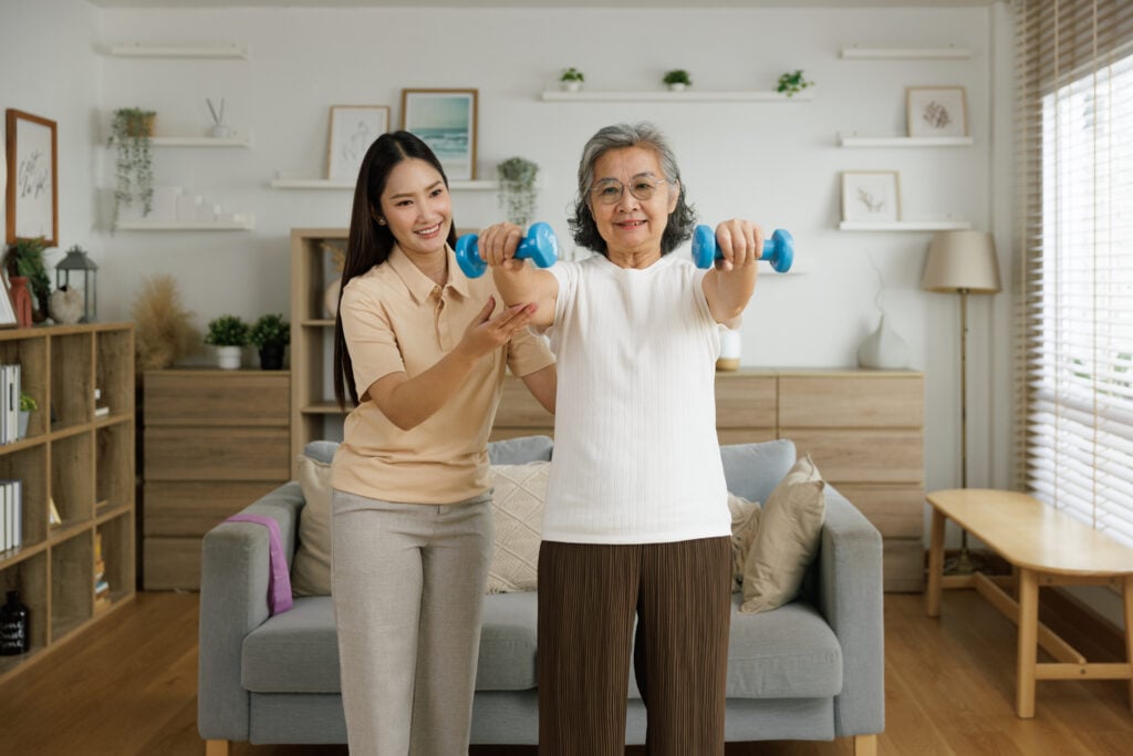 Senior and caregiver doing exercises