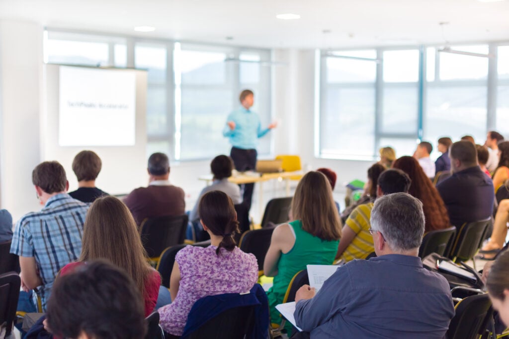 attendees enjoy an educational lecture in a brightly lit room